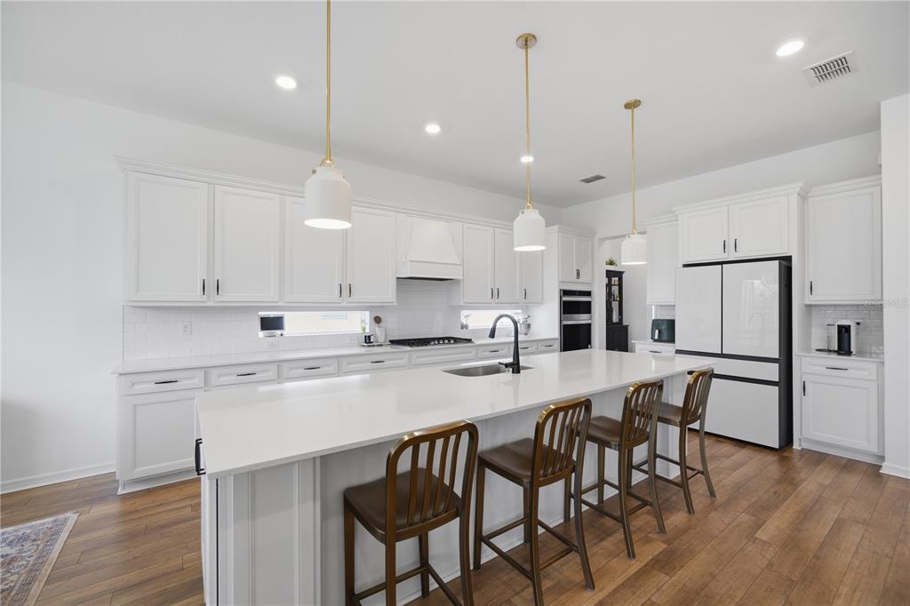 13816 Sharp Hawk Drive Riverview, FL 33569 - Photo 12 of 76 a kitchen with stainless steel appliances a dining table chairs sink and microwave