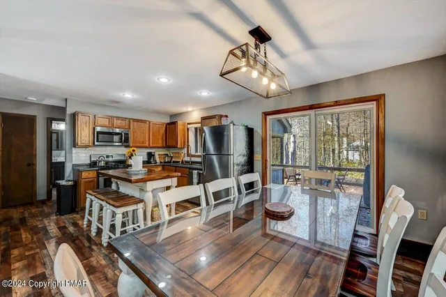 a view of a dining room with furniture a kitchen and chandelier