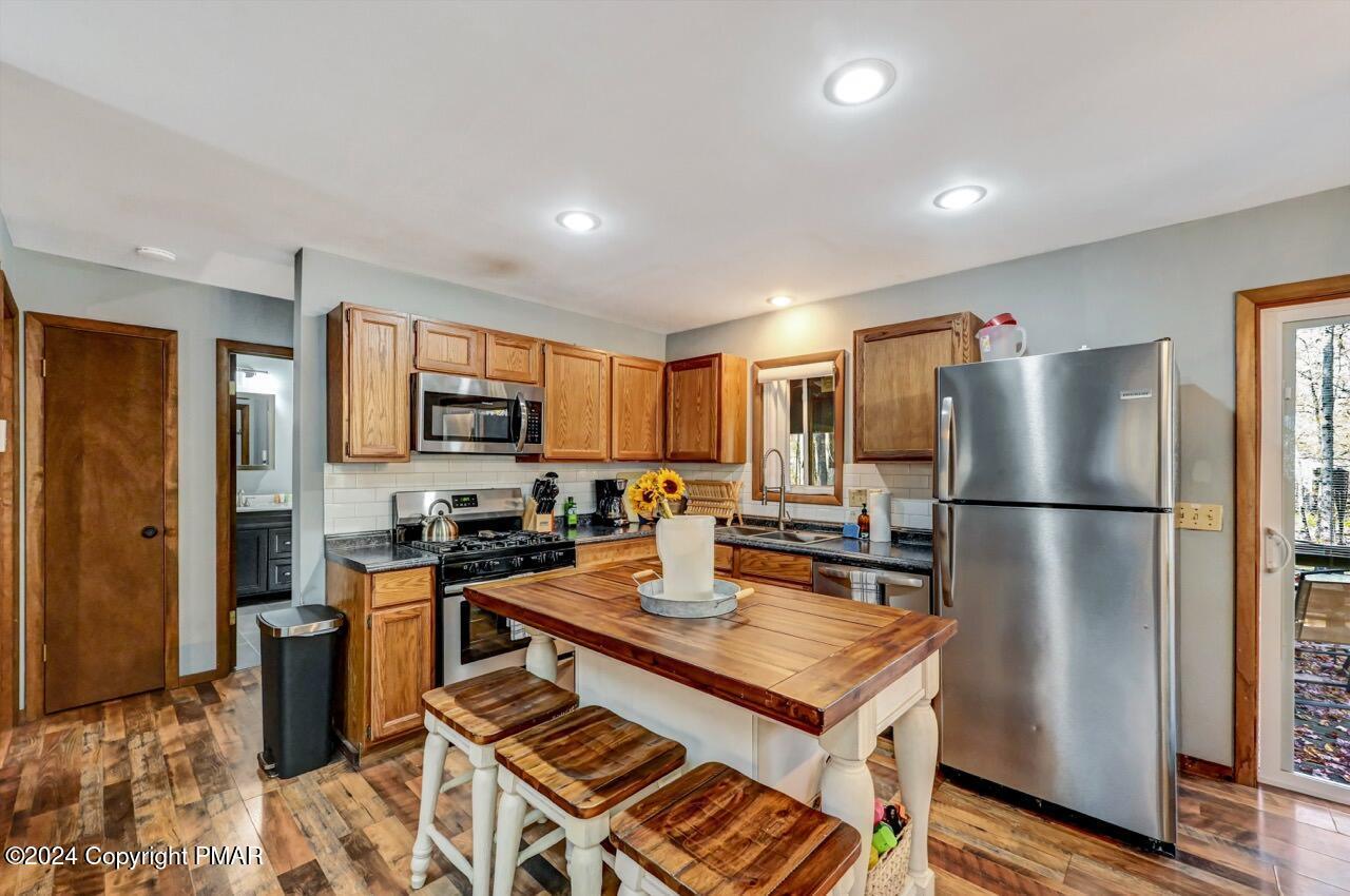 209 Kit Carson Circle Pocono Pines, PA 18350 - Photo 9 of 44 a kitchen with kitchen island a counter top space a sink stainless steel appliances and cabinets