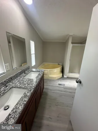 a bathroom with a granite countertop double vanity sink and mirror