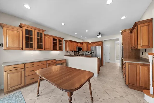 a kitchen with stainless steel appliances granite countertop a refrigerator and a stove top oven