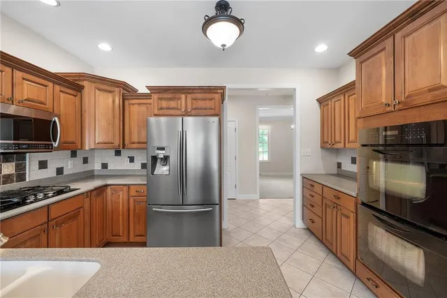 a kitchen with stainless steel appliances granite countertop a refrigerator stove top oven a sink and dishwasher