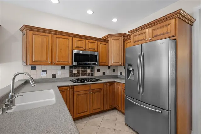 a kitchen with stainless steel appliances granite countertop a refrigerator and a sink