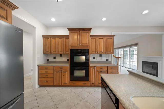 a kitchen with granite countertop a stove top oven and refrigerator