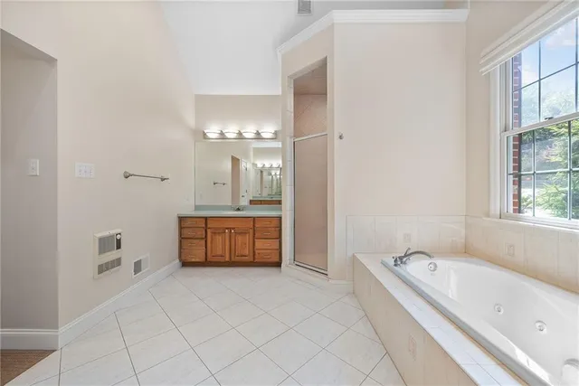 a bathroom with a tub a sink and a large mirror