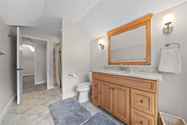 a spacious bathroom with a toilet sink and mirror