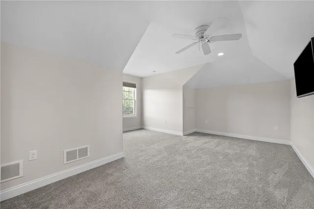 an empty room with a ceiling fan and a window