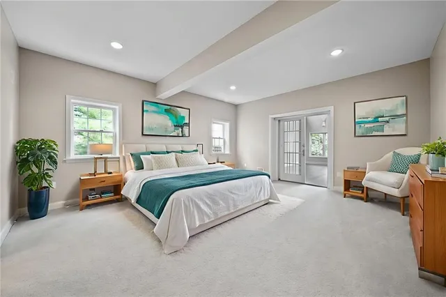 a spacious bedroom with a bed a couch and potted plant