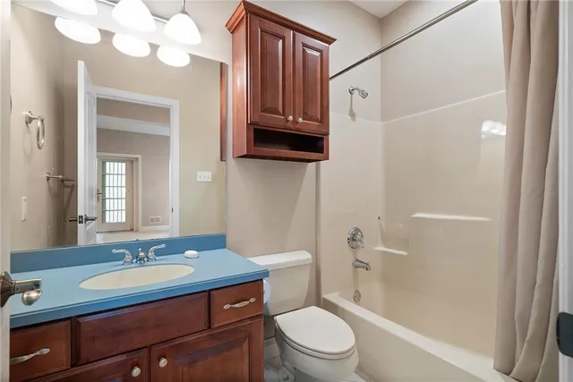 a bathroom with a granite countertop sink toilet a mirror a vanity and shower