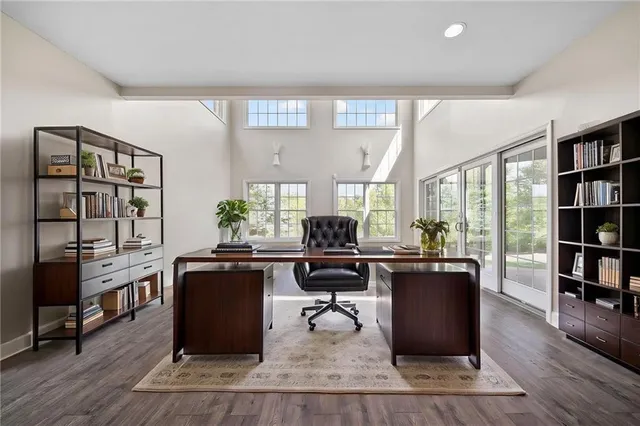 a view of a workspace with furniture and a book shelf