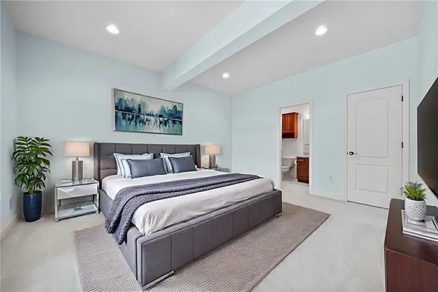 a spacious bedroom with a bed and potted plant