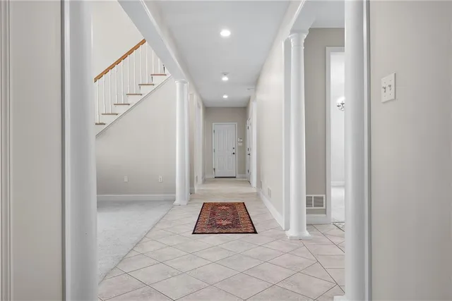 a view of a hallway with wooden floor and staircase