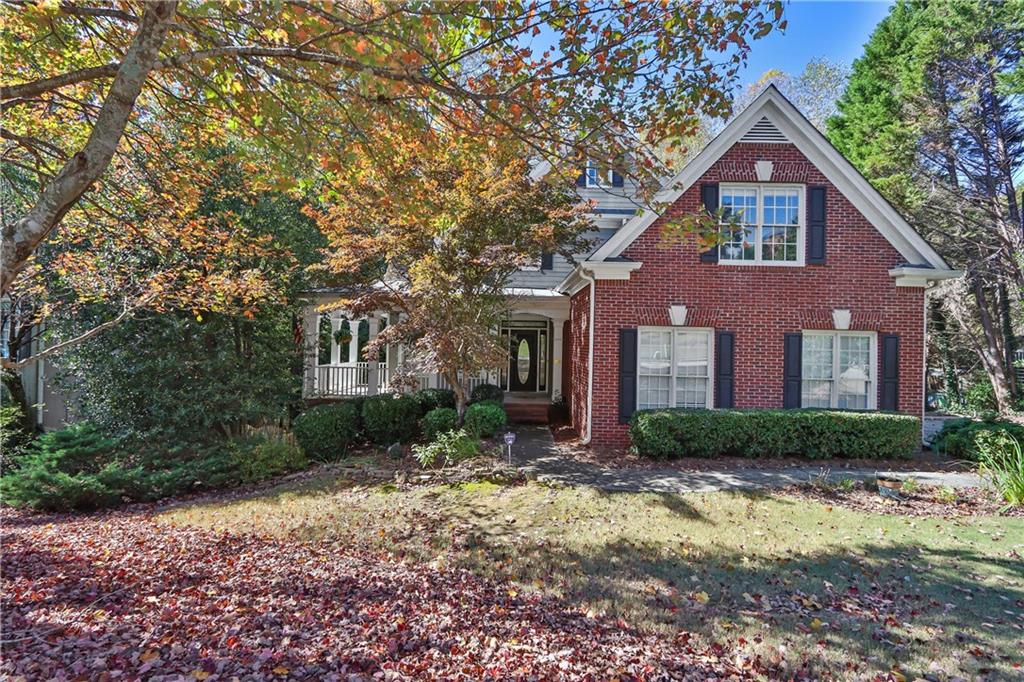 a front view of a house with a yard and trees