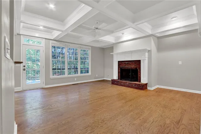 en view of an empty room with a fireplace and a window