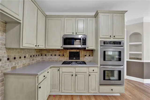a kitchen with granite countertop a stove microwave and cabinets