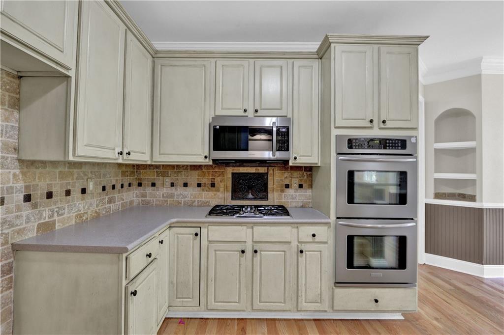 1872 Bakers Mill Road Dacula, GA 30019 - Photo 22 of 47 a kitchen with granite countertop a stove microwave and cabinets