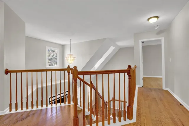 a view of a hallway with wooden floor and windows
