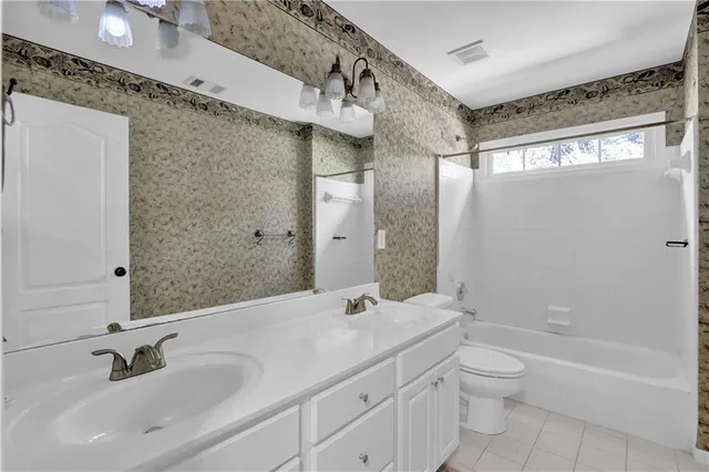 a bathroom with a granite countertop sink a toilet and shower
