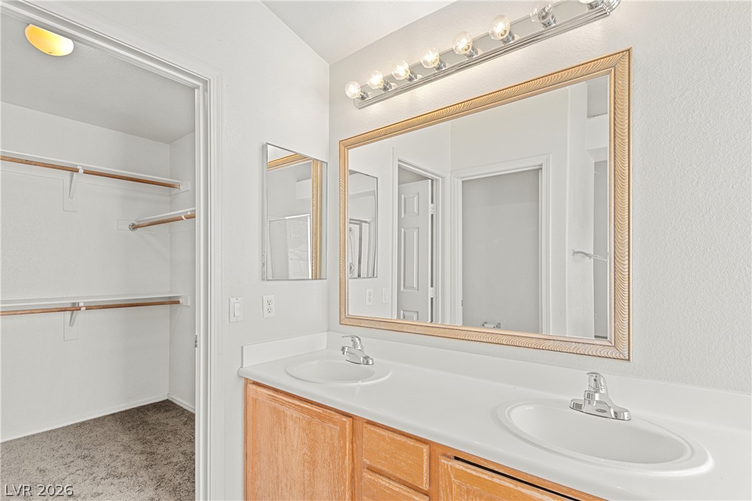 1815 Stablegate Avenue Henderson, NV 89012 - Photo 19 of 28 Double vanity sinks and bright lighting enhance this well-appointed primary bathroom.