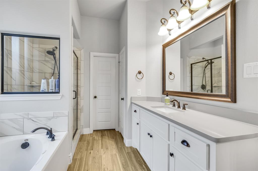 1306 Elizabeth Street Anna, TX 75409 - Photo 35 of 36 Bathroom with vanity, a bath, light wood-type flooring, and a stall shower