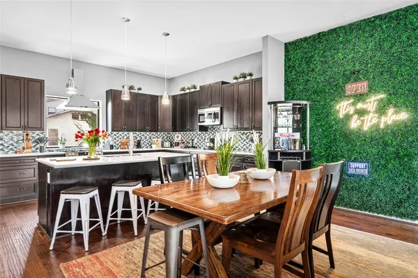 a dining room with furniture wooden floor and kitchen view