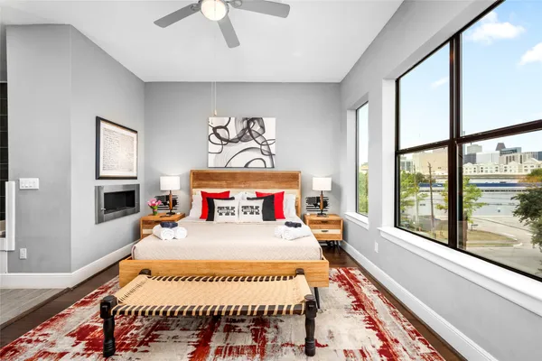 a bedroom with a bed and a large window with the outer view