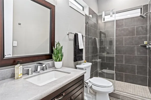 a bathroom with a sink a toilet and shower
