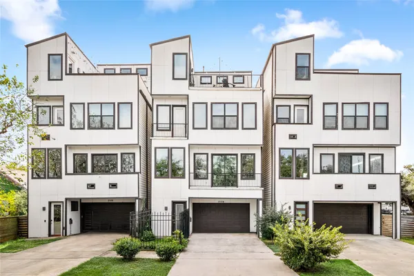 a front view of a building with a garden and swimming pool