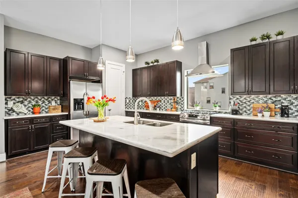 a kitchen with stainless steel appliances kitchen island granite countertop a table and chairs in it