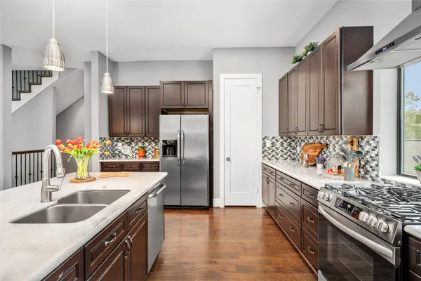 a kitchen with stainless steel appliances granite countertop a sink stove and refrigerator