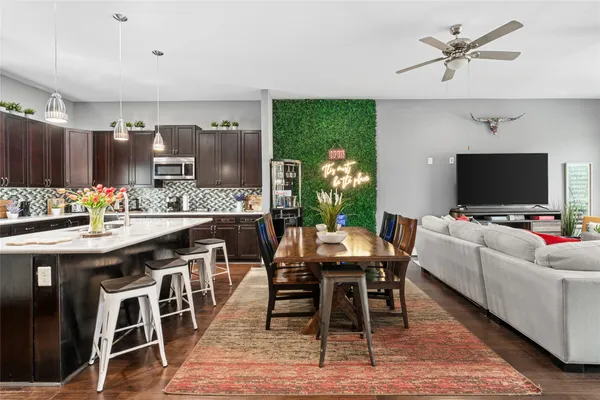 a kitchen with a table chairs refrigerator and microwave