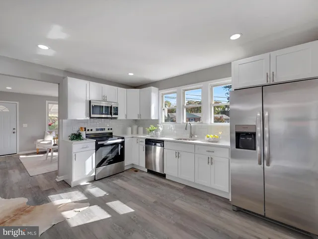 a kitchen with stainless steel appliances granite countertop a refrigerator stove microwave and sink