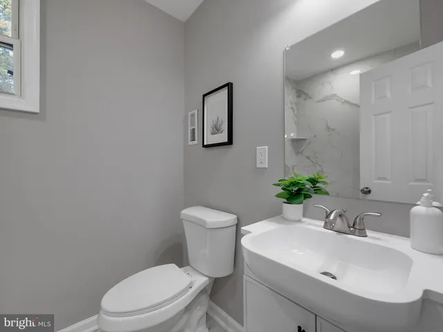 a bathroom with a sink toilet and a mirror