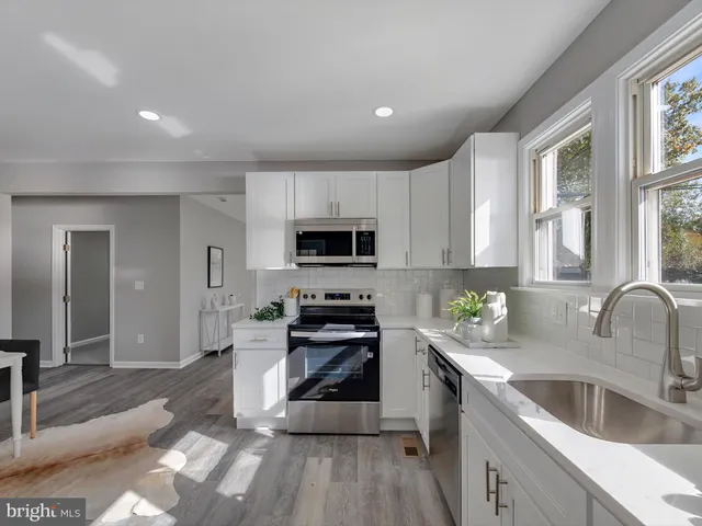 a kitchen with granite countertop a stove sink and cabinets