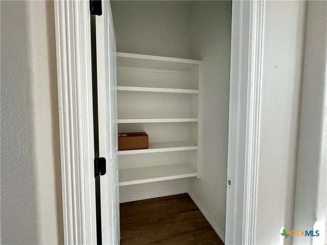a view of walk in closet with empty racks