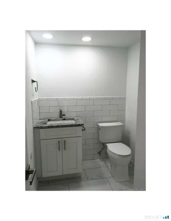 a bathroom with a toilet a sink and mirror