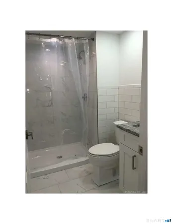 a bathroom with a toilet and a shower