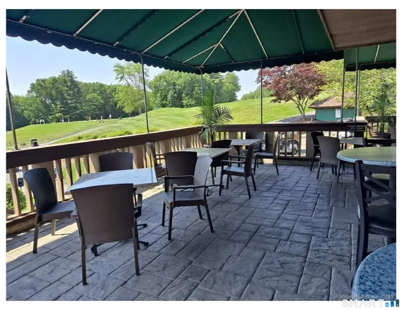 a patio with wooden floor a yard a table and chairs