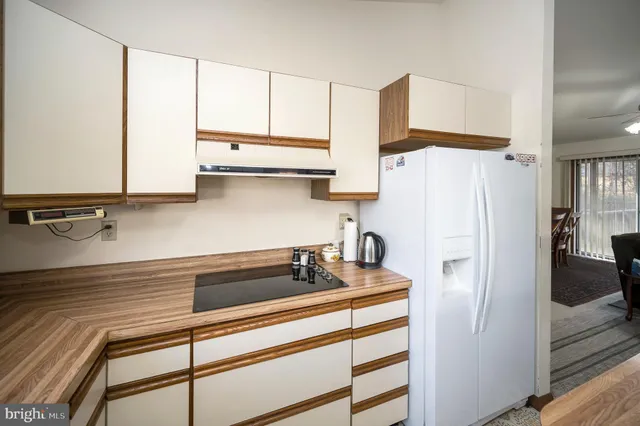a kitchen with kitchen island a stove a sink a refrigerator and cabinets