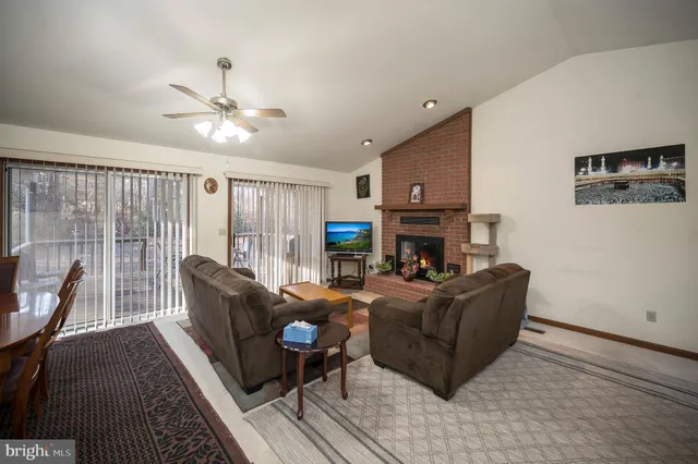 a living room with furniture a fireplace and a flat screen tv