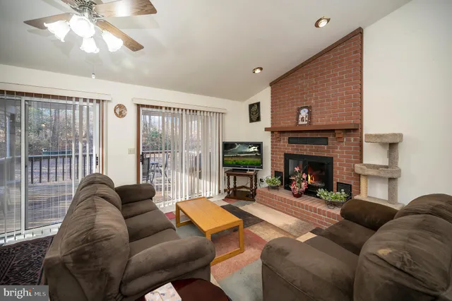 a living room with furniture a fireplace and a large window