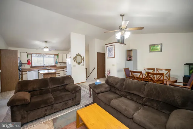 a living room with furniture a ceiling fan and a window