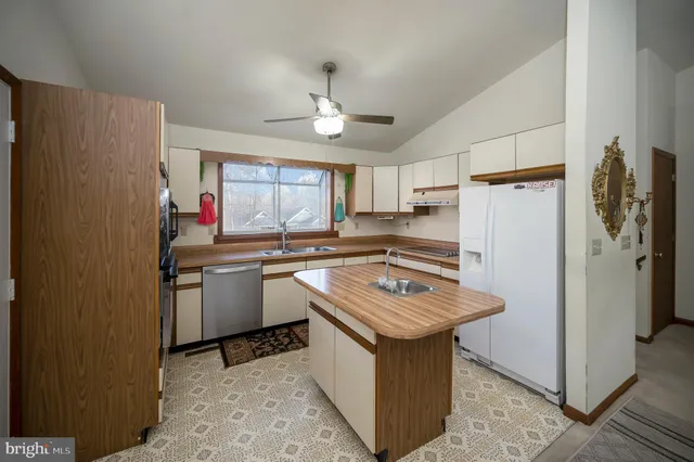 a kitchen with stainless steel appliances granite countertop a refrigerator a sink dishwasher a stove with white cabinets