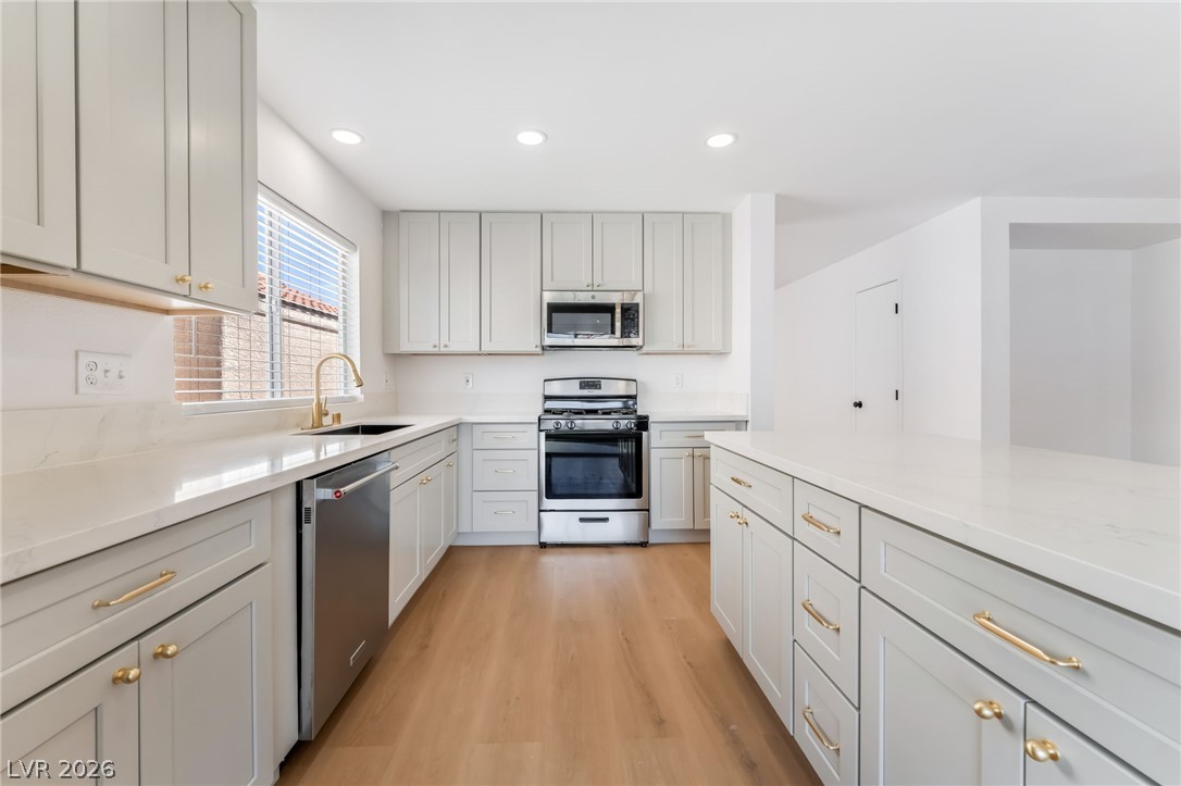 668 Rising Brook Drive Henderson, NV 89011 - Photo 7 of 22 Culinary dreams come alive in this well-appointed kitchen featuring light cabinetry and sleek countertops.