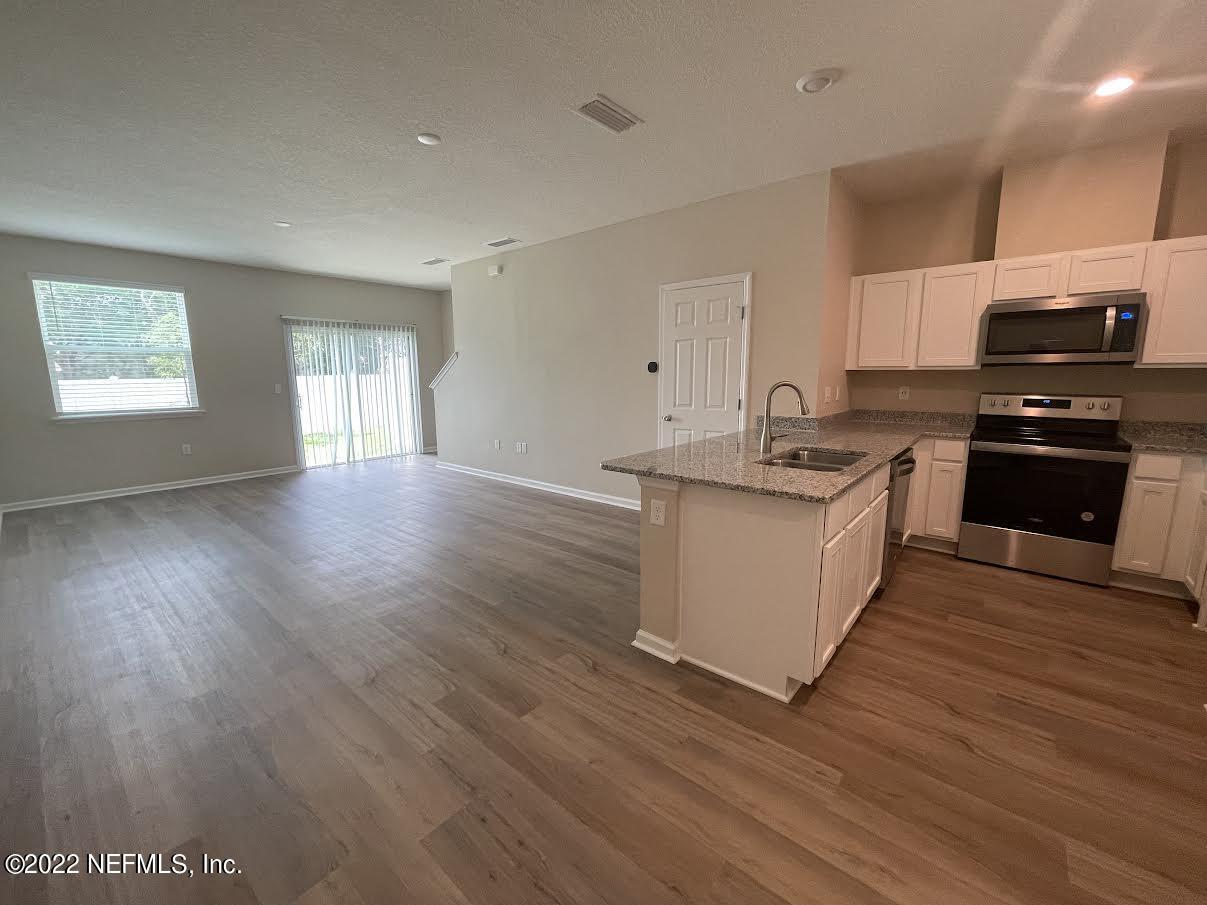11792 Junegrass Road Jacksonville, FL 32258 - Photo 16 of 16 a kitchen with stainless steel appliances granite countertop a stove a sink and a refrigerator