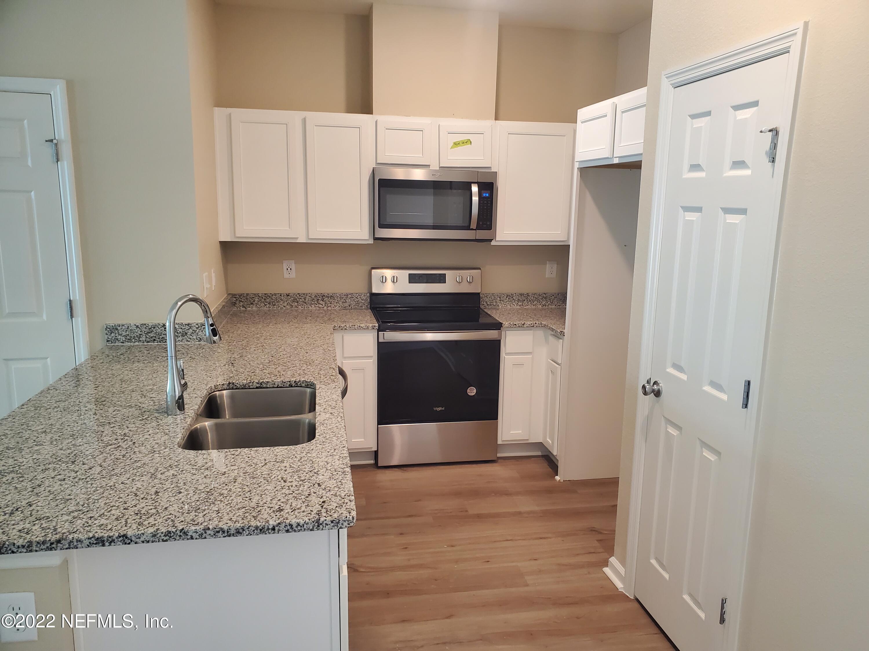 11792 Junegrass Road Jacksonville, FL 32258 - Photo 3 of 16 a kitchen with granite countertop a sink stove and refrigerator
