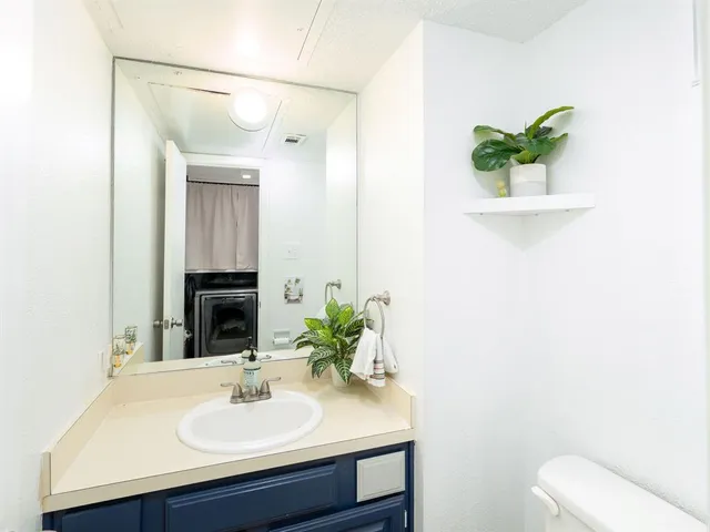 a bathroom with a sink a toilet and a mirror