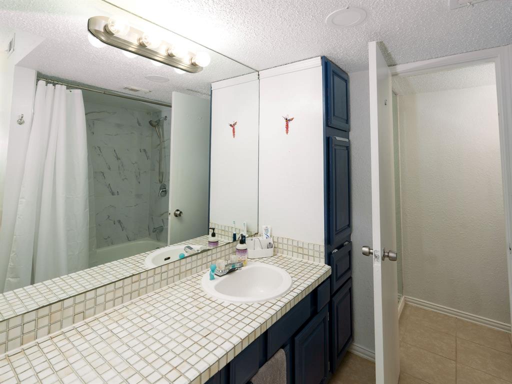 18240 Midway Road, Unit 205 Dallas, TX 75287 - Photo 15 of 27 a bathroom with a sink and a mirror