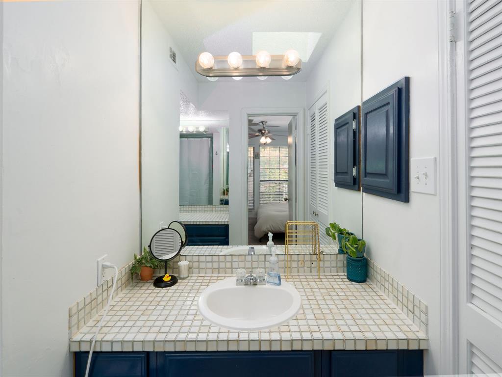 18240 Midway Road, Unit 205 Dallas, TX 75287 - Photo 16 of 27 a bathroom with a sink and a mirror