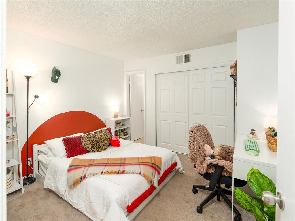 18240 Midway Road, Unit 205 Dallas, TX 75287 - Photo 17 of 27 a bedroom with a bed and a chandelier